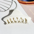 Dettaglio macro della molletta per capelli bianco crema con denti intrecciati su sfondo neutro - Beige Solido UV