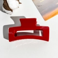 Detail of a bright red 8.5cm square hair claw clip with glossy finish on white leather texture - Bright Red