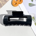 Macro detail of a glossy black rectangular hair claw clip with a hollow design - 10.5cm Bright Black