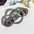 Macro view of a dark grey infinity knot hair clip with a silver metal spring fastener - Dark Gray