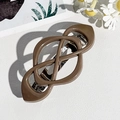 Close-up of a matte dark brown cross knot hair clip with a silver metal spring back - Dark Coffee
