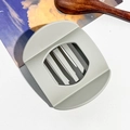 Détail de la grande pince à cheveux mate incurvée gris clair sur fond de cuisine rustique - Barrette Lingot 9.5cm / Gris Beige Mat