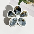 Détail de pince à cheveux fleur en acétate marbré avec une perle centrale - Café & Noir