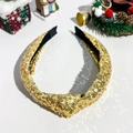 Nahaufnahme des goldfarbenen Pailletten-Haarreifens mit Knotendesign für festliche Frisuren - Gold Pailletten Weihnachten Stirnband