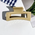 Detailed top view of a large ginger matte square claw clip on white leather background - 8.5cm Milk Coffee
