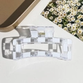 Detailansicht der transparenten Haarklammer mit Karomuster und goldener Metallfeder - Transparentes Schachbrettmuster-Stil