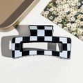 Detailed view of checkered square hair claw clip on textured background - Black Checkerboard Style