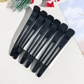 Detailed view of six black non-slip hair root clips set against a festive background - Style A / Black