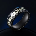 Dettaglio di un anello in titanio nero con motivo a nodo celtico dorato e finitura lucida - Taglia US 7 / Base Nera