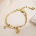 Bracciale a serpente placcato oro 18 carati con ciondoli a sole e medaglia religiosa - Stile Maria Religiosa e Stella (32117)