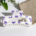 Cream hair claw clip featuring purple bow patterns in a minimalist square design - Purple Bow Print (142-3)