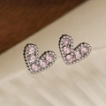 Dettaglio macro di orecchini a cuore in argento con zirconi rosa su un vassoio - Rosa (45847)