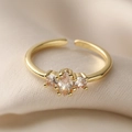 Eleganter vergoldeter offener Ring mit Zirkonia-Steinen auf beigefarbenem Seidenstoff - Einstellbar Offen / Weiß