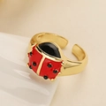 Minimalist 18K gold plated open ring with red ladybug design on a white wave stand - Adjustable Open / Ladybug Style Two (14699)