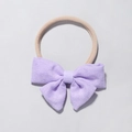 Close-up of lilac textured fabric bow on soft beige high-elastic nylon baby headband - Lavender