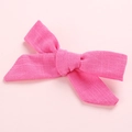 Detailed macro view of pink linen cotton bow hair clip with textured fabric weaving - Rose Red
