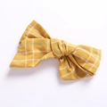 Detailed view of yellow plaid cotton linen bow hair clip with textured fabric pattern - Yellow Check