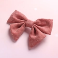 Detailed macro view of a red checkered linen cotton bow hair clip for girls - Brown