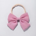 Detail of red and white striped bow baby headband with elastic nude nylon strap - Red and White Striped