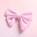 Detailed close-up showing the pink cotton linen texture of a classic girl's bow hair clip - Pink