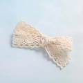 Dettaglio macro di un fiocco in pizzo bianco sporco con bordi smerlati fatti a mano - Stile Ricamo con Bordo Ondulato / Bianco Sporco