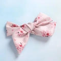 Vista dall'alto di un fermaglio a fiocco con stampa floreale rosa e trama in twill - Fiocco / Stampa