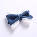Détail du nœud papillon en feutre bleu avec bordure à pompons blancs pour enfants - Bleu marine