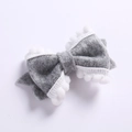 Détail d'un nœud papillon en feutre gris fait main avec bordure décorative à pompons blancs - Gris