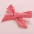 Close-up of a pink textured linen bow hair clip for girls with a solid color design - Watermelon red