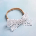 Dettaglio fascia per neonati in nylon con fiocco in pizzo bianco e trama elastica morbida - Stile Petalo Traforato Bianco (6)