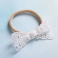 Dettaglio fascia per neonati in nylon con fiocco in pizzo floreale bianco su sfondo blu - Stile Pizzo Bianco Puro (5)