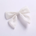 Détail de la pince à cheveux nœud papillon en coton blanc montrant la texture du tissu - Blanc