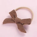 Detailed view of brown corduroy bow baby headband with highly elastic nylon strap - Tan