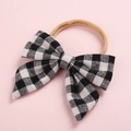 Détail d'un bandeau à nœud à carreaux noir et blanc pour bébé avec ruban en nylon souple - Noir Style 1