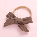 Detailed view of brown corduroy bow newborn headband with soft nude nylon elastic band - Dark Khaki