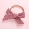 Close-up of baby headband featuring a dusty pink corduroy bow with high-elastic nylon band - Dark Pink