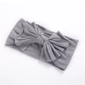 Détail d'un bandeau gris souple en nylon pour bébé avec un grand nœud sur fond blanc - Gris