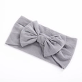 Detailed view of grey elastic nylon headband with a large decorative bow for infants - Gray