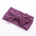 Vue détaillée du bandeau en nylon violet foncé avec un grand nœud fait main pour bébés - Mauve Clair
