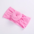 Close-up of pink nylon baby headband featuring a soft donut-shaped floral knot detail - Water Pink