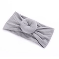 Vista macro de una diadema gris de nailon para bebé con detalle de nudo donut - Gris