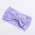 Close-up of light purple baby headband showing soft knit texture and pom-pom edge - Purple