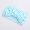 Detail of light blue baby headband featuring a soft bow and decorative pom-pom trim - Sky Blue