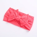 Close-up of bright pink elastic infant headband with a textured knitted bow detail - Watermelon red