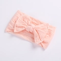 Detailed view of baby headband featuring a soft light pink oversized bow on nylon band - Dark Pink