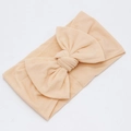Detail of soft pale pink nylon headband featuring an oversized handmade bow for infants - Light Orange