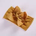 Detailed view of bright yellow high-elastic nylon headband with large grosgrain ribbon bow - Turmeric