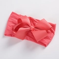 Detailed close-up of coral red ribbed ribbon bow on soft elastic nylon baby headband - Watermelon red