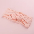 Détail du bandeau bébé en nylon rose doux avec décoration de nœud torsadé tricoté - Rose Foncé