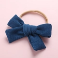 Détail du nœud en velours côtelé bleu marine sur un bandeau élastique doux pour bébés - Denim Bleu